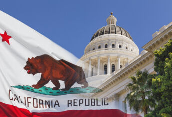 California sets August deadline for GHG emissions reporting Photo of a faded California state flag laid over the California Capitol.