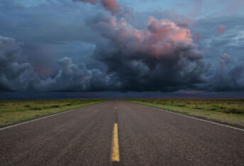 Desert road with storm clouds