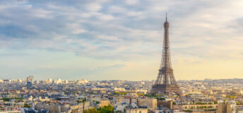 Aerial view of Paris with Eiffel Tower and Champs Elysees from the roof of the Triumphal Arch. Panoramic sunset view of old town of Paris. City skyline. Popular travel destination.