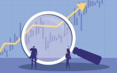 Two businessmen using a magnifying glass to observe market trends.