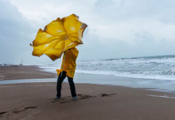 Physical climate risk data: The more you learn, the less you know Person on a beach trying to hold an umbrella on a windy day