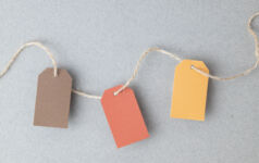 Autumn color palette, blank gift tags with jute twine string on a gray textured surface with copy space.